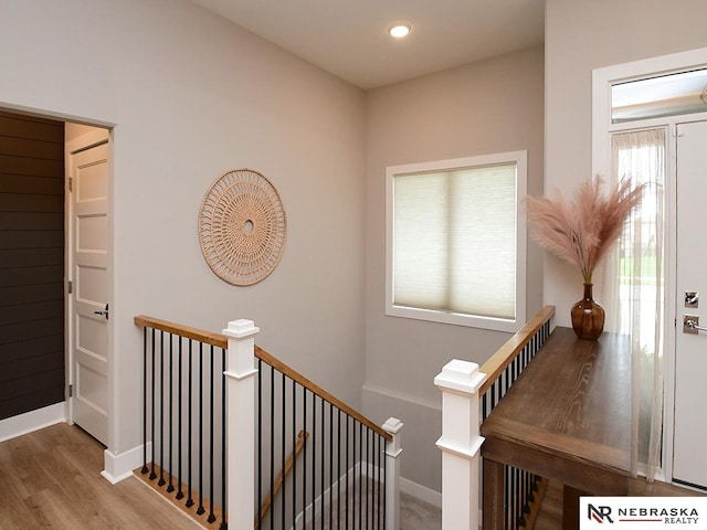interior space featuring recessed lighting, baseboards, an upstairs landing, and wood finished floors