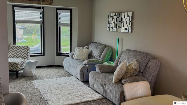 carpeted living room with baseboards