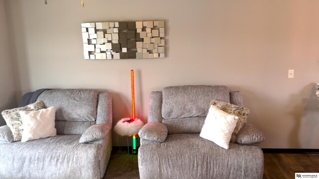 living area with baseboards and wood finished floors