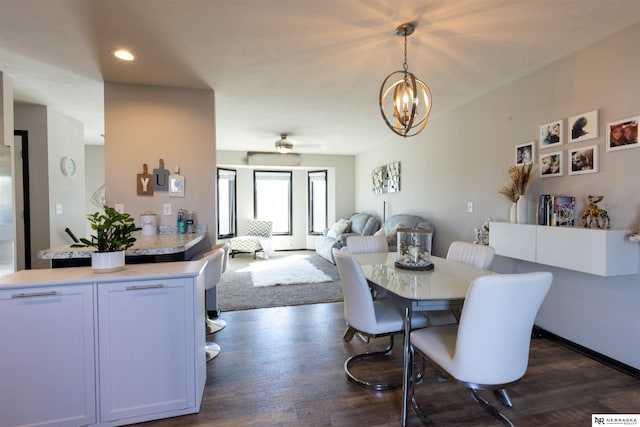 dining space with recessed lighting, ceiling fan with notable chandelier, and dark wood-type flooring
