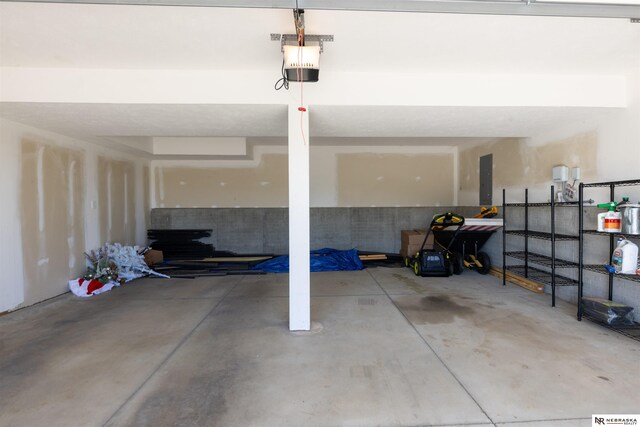 garage with a garage door opener and electric panel