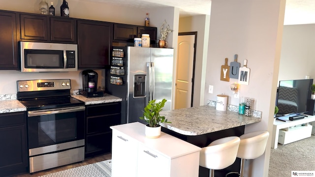 kitchen with light countertops, appliances with stainless steel finishes, and dark brown cabinets