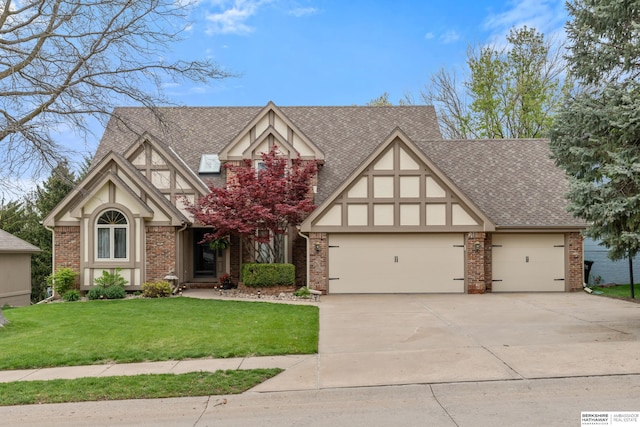 tudor house featuring a garage, a shingled roof, concrete driveway, and a front yard