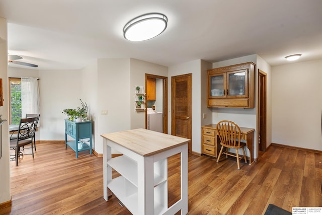 kitchen with light wood-style floors, baseboards, and brown cabinetry