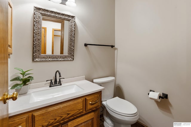 half bathroom with vanity, visible vents, and toilet