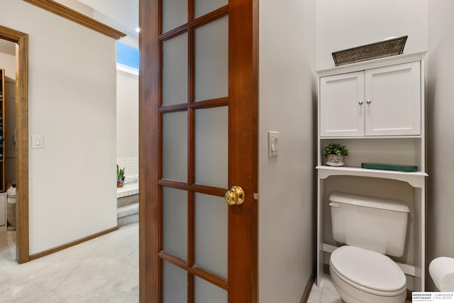 bathroom featuring toilet and baseboards