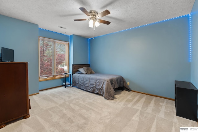 carpeted bedroom with baseboards, ceiling fan, and a textured ceiling