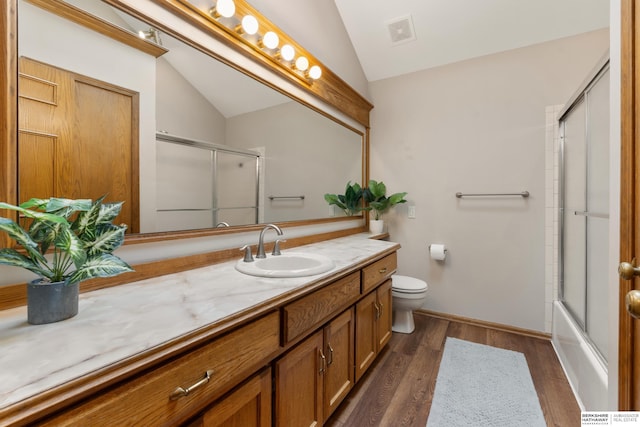 bathroom with visible vents, wood finished floors, vanity, toilet, and lofted ceiling
