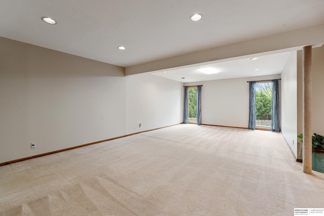 empty room featuring light colored carpet, recessed lighting, baseboards, and plenty of natural light