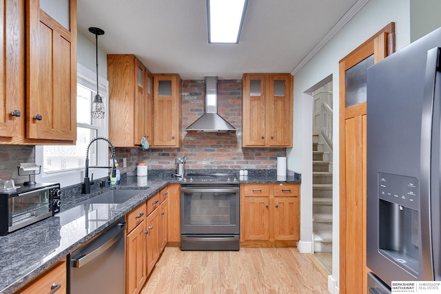 kitchen with decorative backsplash, a toaster, wall chimney range hood, a sink, and stainless steel appliances