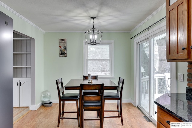 dining area featuring a notable chandelier, a wealth of natural light, and light wood-type flooring