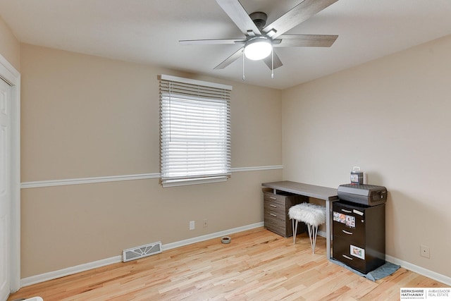 home office featuring baseboards, a ceiling fan, wood finished floors, and visible vents