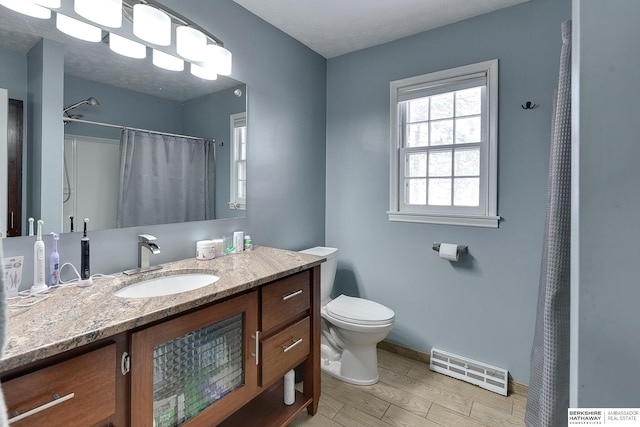 full bathroom featuring vanity, toilet, baseboards, wood tiled floor, and visible vents