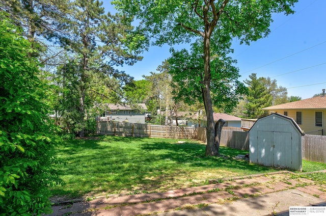 view of yard with a storage shed, an outdoor structure, and a fenced backyard