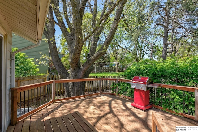 wooden terrace featuring a fenced backyard and a grill