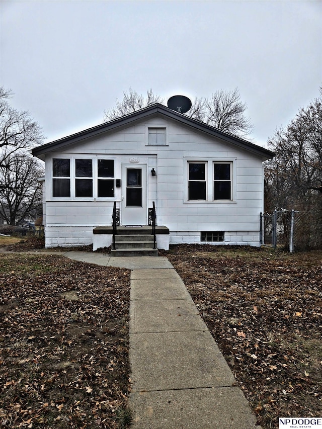 bungalow-style home with entry steps and fence