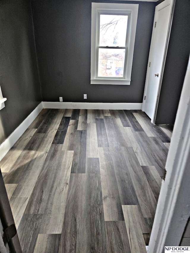 unfurnished room featuring wood finished floors and baseboards