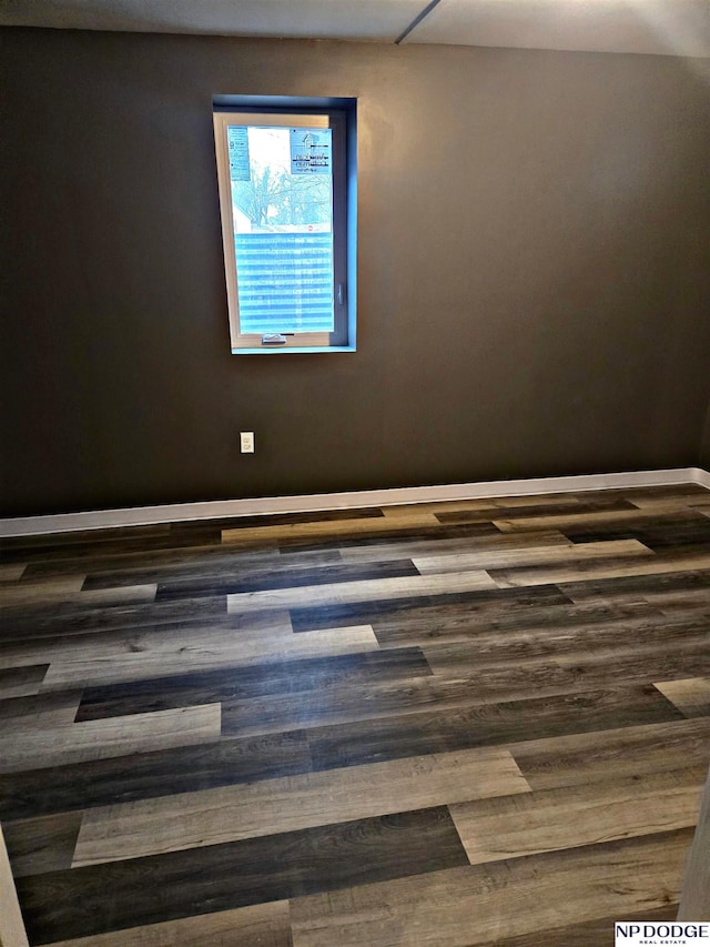 unfurnished room featuring baseboards and wood finished floors