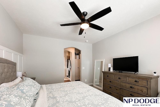 bedroom with arched walkways and a ceiling fan
