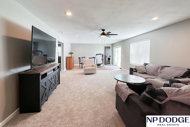 living area featuring light carpet, a ceiling fan, baseboards, and recessed lighting