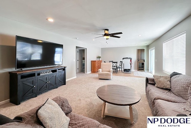 living area featuring recessed lighting, a ceiling fan, baseboards, and light carpet