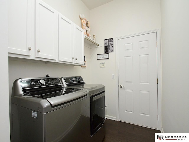 clothes washing area featuring baseboards, washer and dryer, dark wood-type flooring, and cabinet space