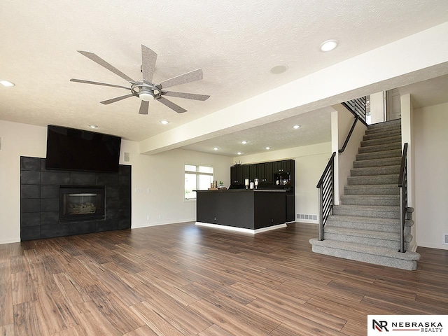 unfurnished living room featuring stairs, a ceiling fan, wood finished floors, and recessed lighting
