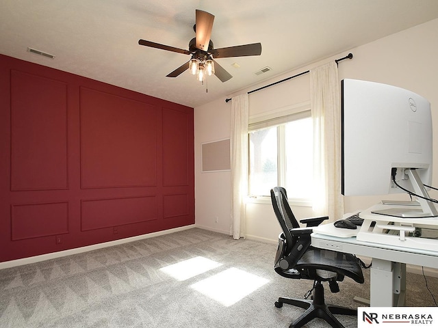 home office with ceiling fan, baseboards, visible vents, and light carpet