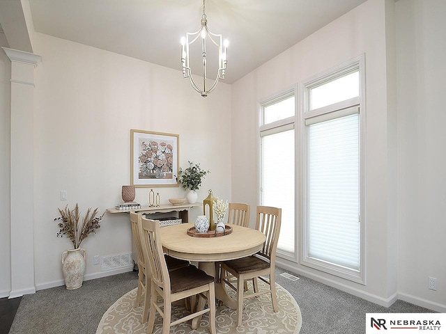 dining space with baseboards, a notable chandelier, carpet flooring, and visible vents