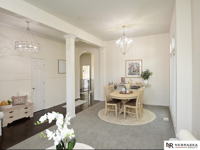 dining room featuring baseboards, arched walkways, and a notable chandelier