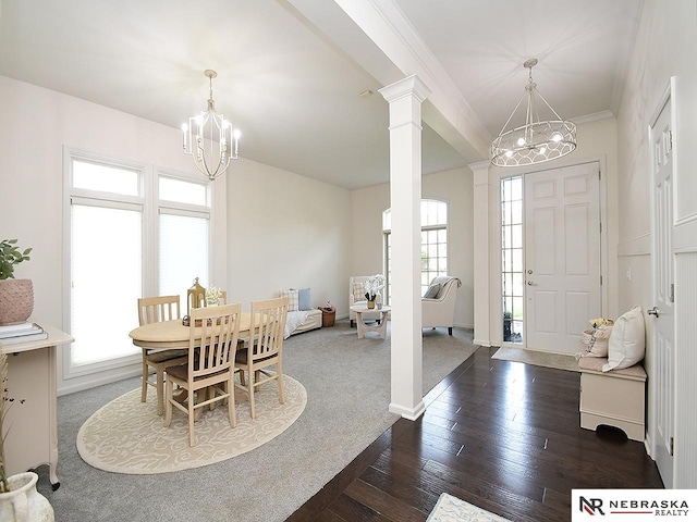 dining area with an inviting chandelier, baseboards, ornamental molding, dark wood-type flooring, and decorative columns