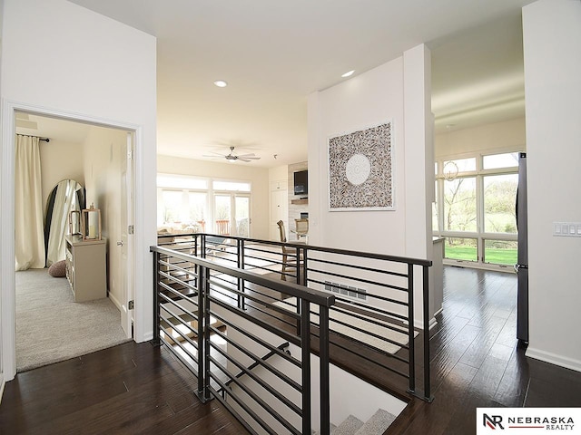 hallway with baseboards, dark wood-style flooring, an upstairs landing, and recessed lighting