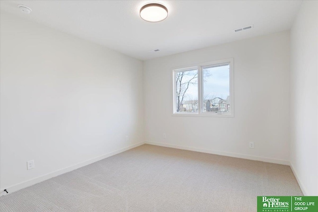 unfurnished room featuring baseboards, visible vents, and light carpet