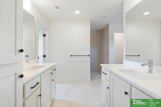full bath with two vanities, visible vents, recessed lighting, and a sink