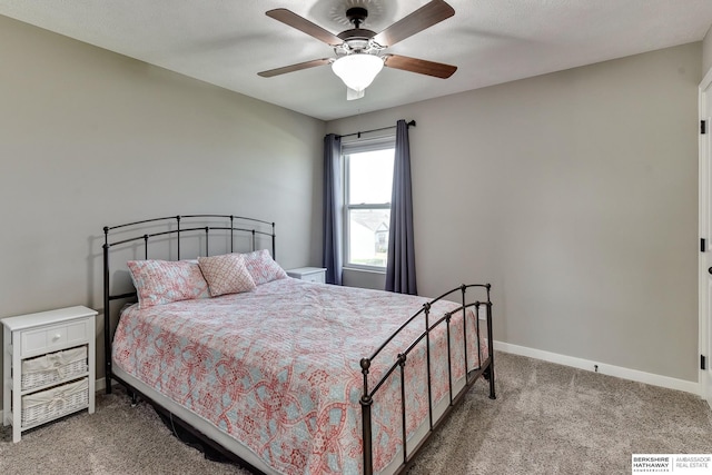carpeted bedroom featuring baseboards and ceiling fan