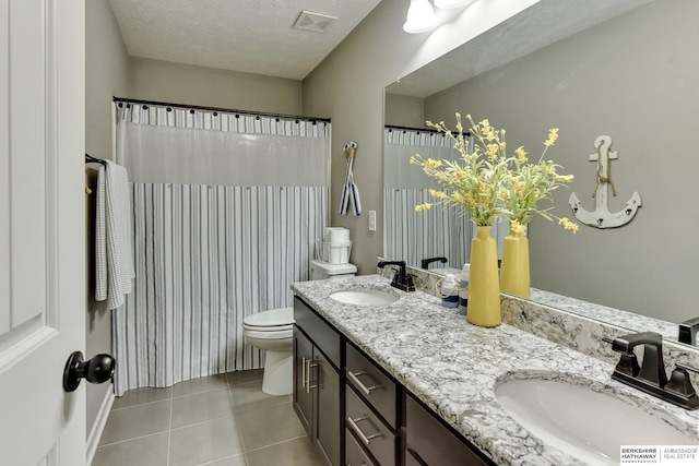 bathroom with a sink, tile patterned flooring, double vanity, and visible vents