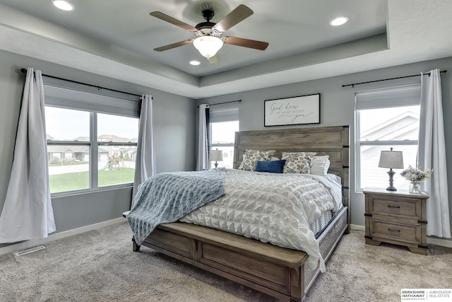 bedroom featuring visible vents, a raised ceiling, baseboards, light carpet, and recessed lighting