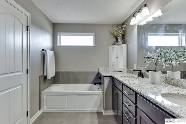 bathroom featuring a sink, tile patterned flooring, a garden tub, and double vanity