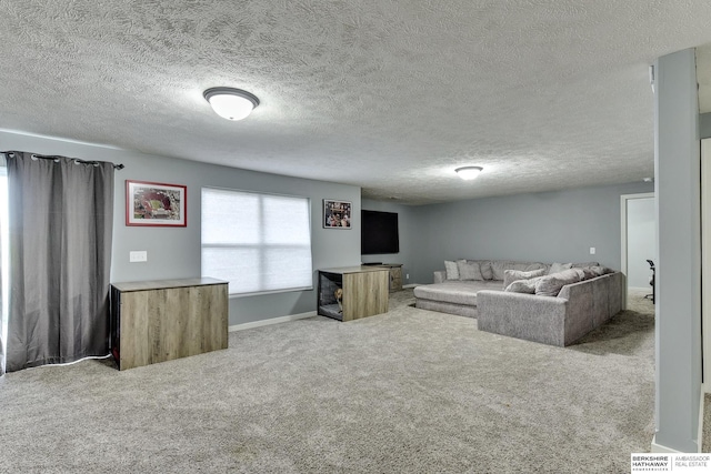 living room with baseboards, carpet flooring, and a textured ceiling