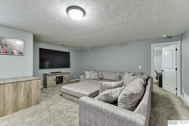 carpeted living area with baseboards and a textured ceiling