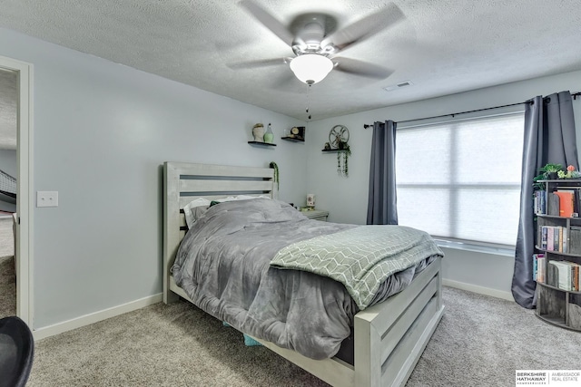 bedroom featuring a textured ceiling, visible vents, baseboards, and carpet