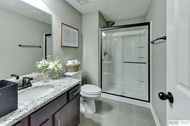 full bath featuring a textured ceiling, tile patterned flooring, a stall shower, vanity, and toilet