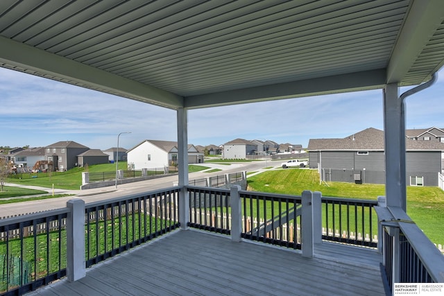 wooden deck with a yard and a residential view