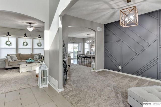 interior space with visible vents, arched walkways, carpet, and baseboards