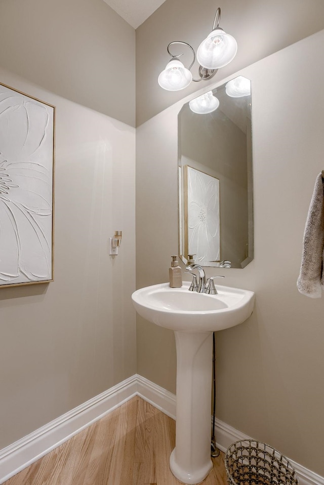bathroom with baseboards and wood finished floors