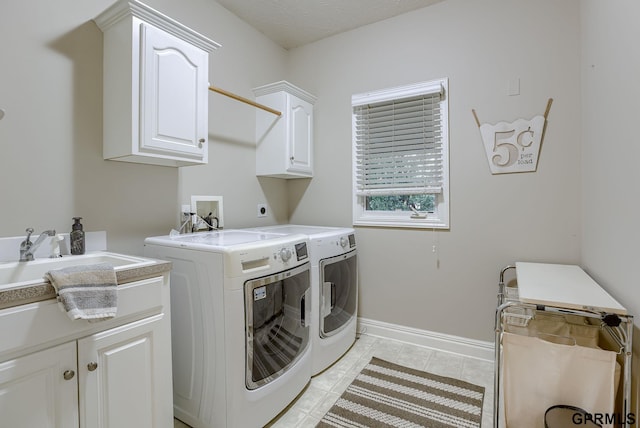 laundry room with washing machine and dryer, light tile patterned flooring, baseboards, a sink, and cabinet space