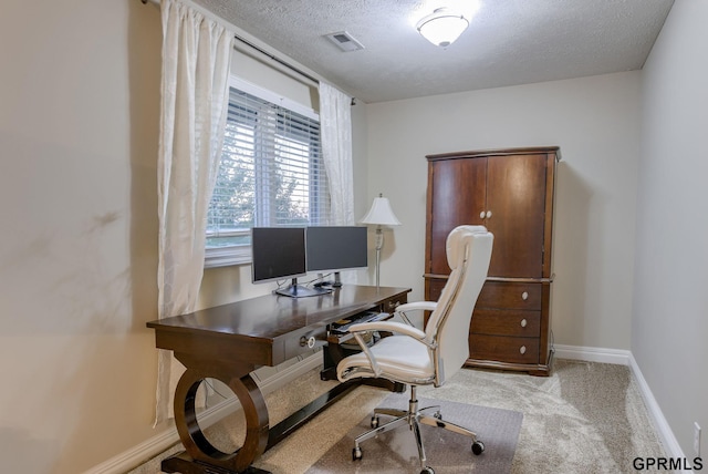 carpeted home office featuring visible vents, a textured ceiling, and baseboards