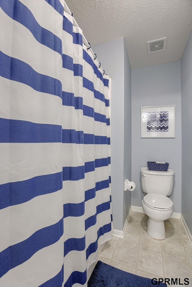full bathroom with visible vents, toilet, baseboards, a textured ceiling, and tile patterned floors