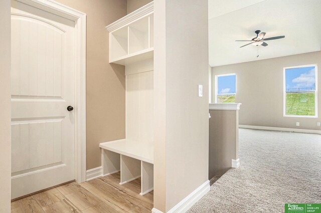 mudroom featuring light wood-type flooring, baseboards, ceiling fan, and light colored carpet