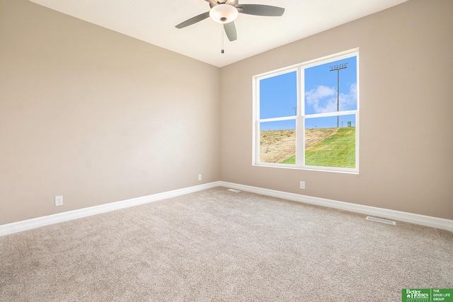 carpeted empty room featuring baseboards, a ceiling fan, and visible vents